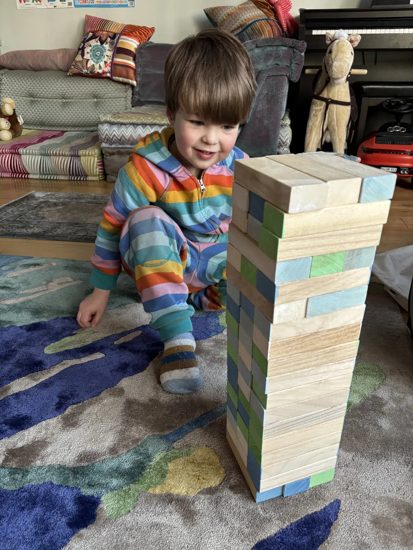 Julia and Vadim's son building a tall wooden block tower