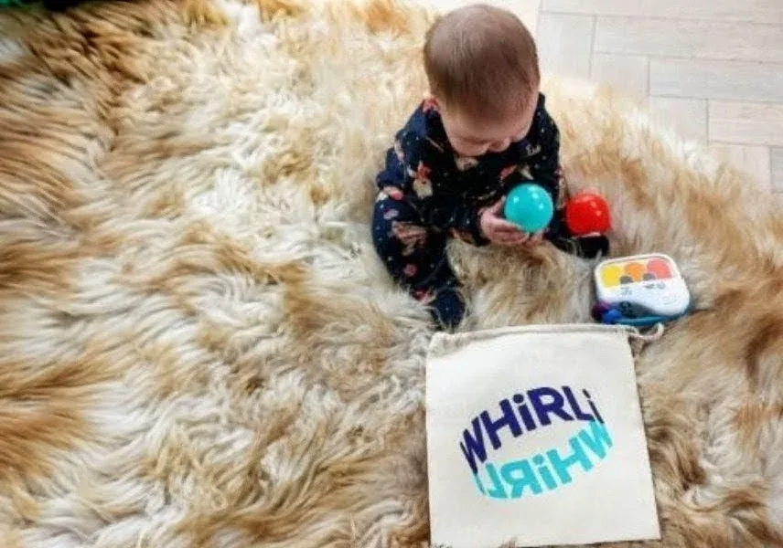 Toddler playing on rug with Whirli bag